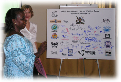 Minister signing committment board